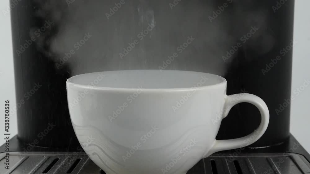 Coffee machine Pouring hot water into a white mug, Close-up Front view Food concept. Coffee machine Pouring hot water into a white mug, Close-up Front view Food concept.