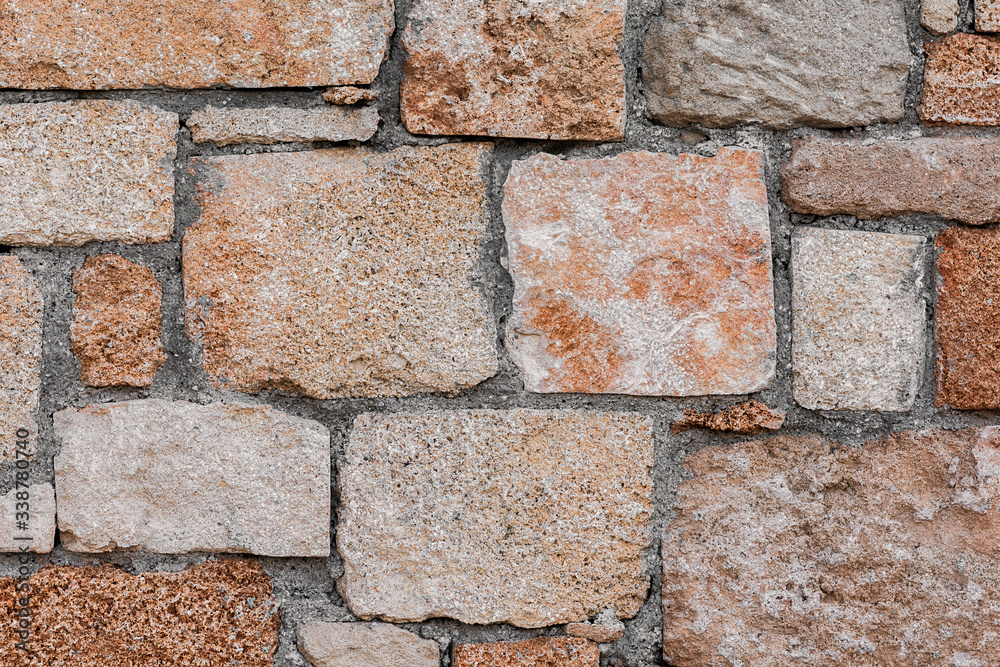 Obraz premium Irregular brown rugged and rustic stone surface background texture shot straight on.