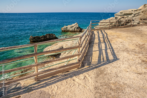 Fence with a shadow on the background of the sea