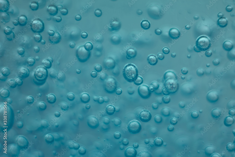 Many round bubbles of the shower gel on the blue background.