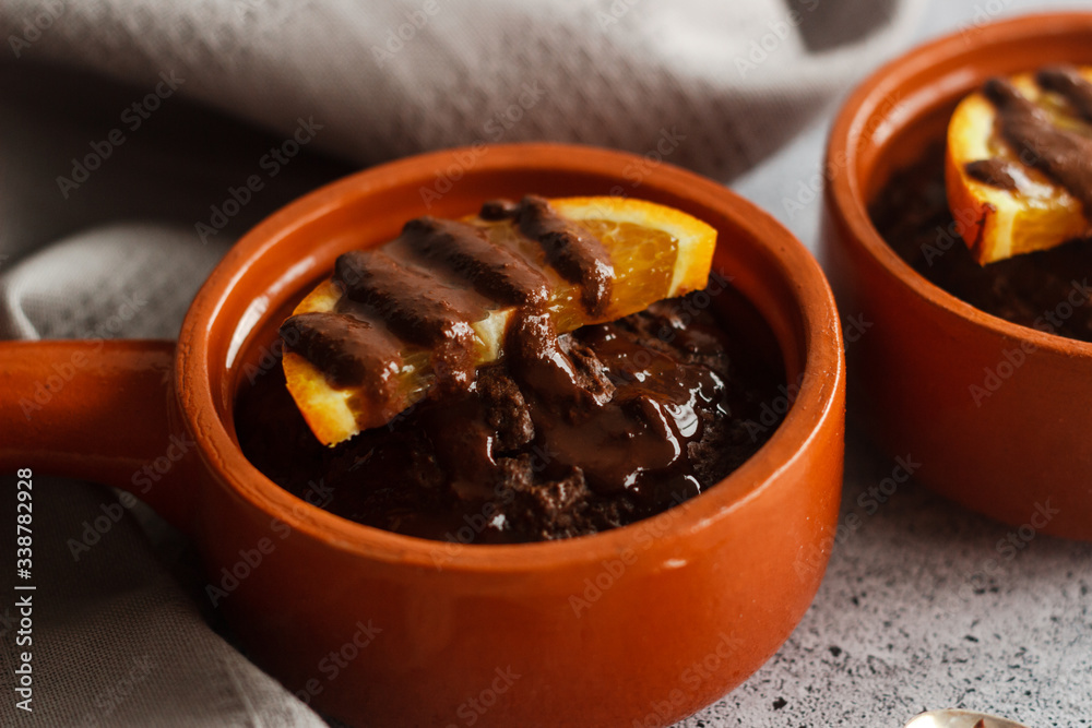 Delicious chocolate pudding with orange. Potted pudding on the table Delicious chocolate pudding with orange. Potted pudding on the table