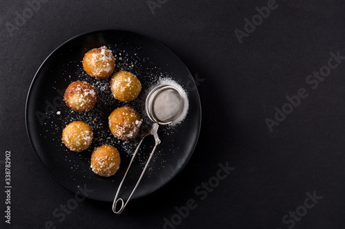 Carnival fritters or buñuelos de viento for holy week on black background top view copy space	 photo