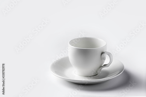white coffee cup, white saucer on a white background with shadows, isolate