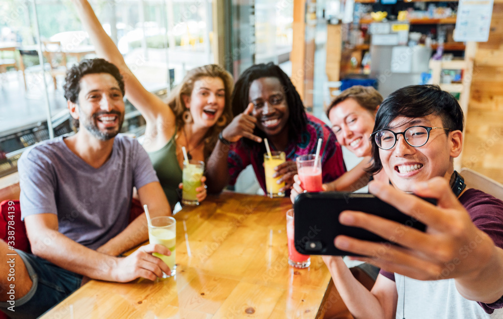 Obraz premium A group of multiethnic friends having a selfie at a restaurant. Concept of friendship