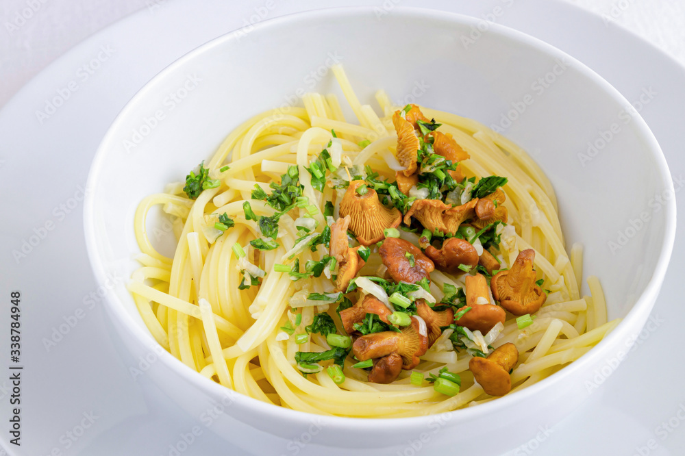 a bowl of spaghetti with chanterelles and parsley