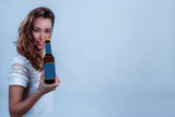 Junge blonde Frau mit einer kleinen Bierflasche in der Hand