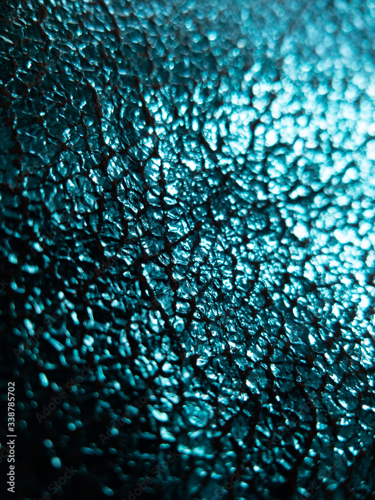 Obraz premium foiled aqua blue fabric background with shinny reflective cracked surface