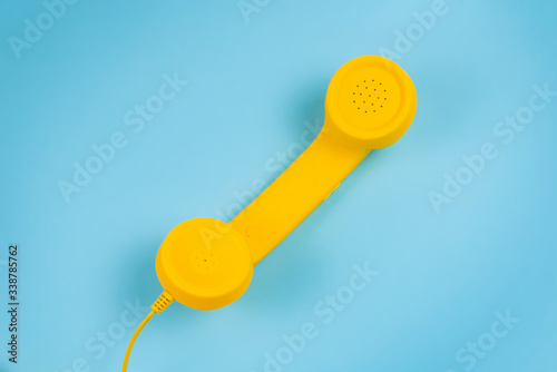 Yellow handset on a blue background.