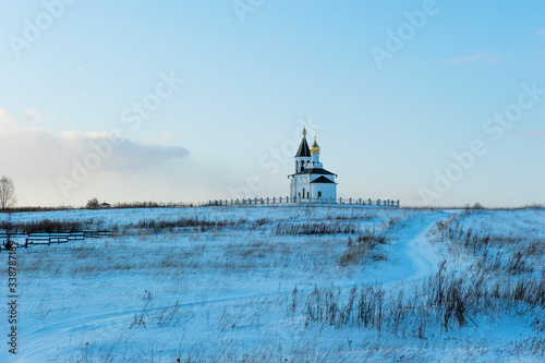 Russian landscape temple on the hill winter road
