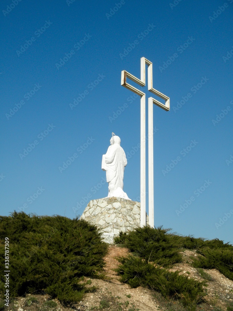 Monument to the victims of the Holodomor in the form of a sculpture of the Holy Mother of God with a cross on the top of Kremyanets Mountain, Ukraine Monument to the victims of the Holodomor in the form of a sculpture of the Holy Mother of God with a cross on the top of Kremyanets Mountain, Ukraine