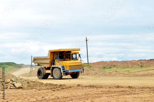 Big yellow mining truck working in the limestone open-pit. Loading and transportation of minerals in the dolomite mining quarry. Belarus  Vitebsk  in the largest dolomite deposit  quarry  Gralevo 