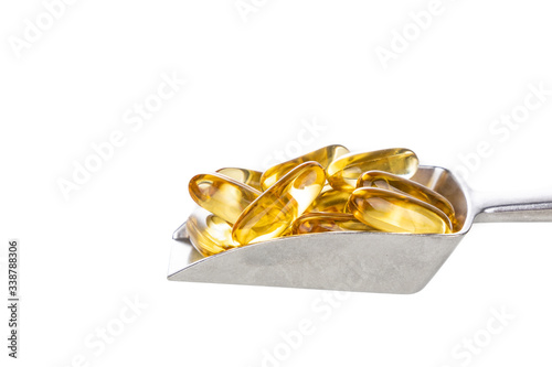Scoop of fish oil gel capsule containing omega-3 polyunsaturated acid EPA and DHA enhances heart and health.