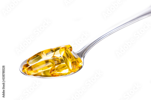 Spoonful of fish oil gel capsule containing omega-3 polyunsaturated acid EPA and DHA enhances heart and health.