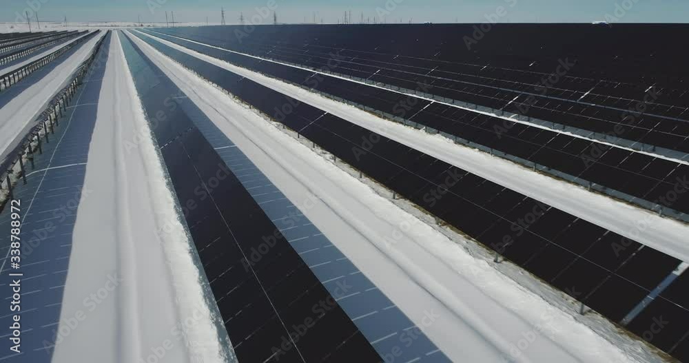 Solar station, power plants, panels farm in snow flat clear field / close up shot at winter sunny day - Aerial drone view