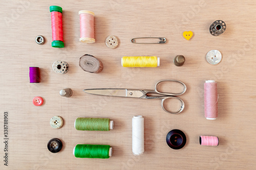 Flat lay of sewing materials: scissors, bobbin, buttons, safety pins, threads. Flat lay, top view