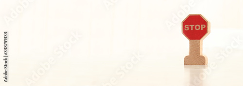 wooden road stop sign stands on a light beige background.Road safety, teaching children  road rules concept. banner,text area, copy space