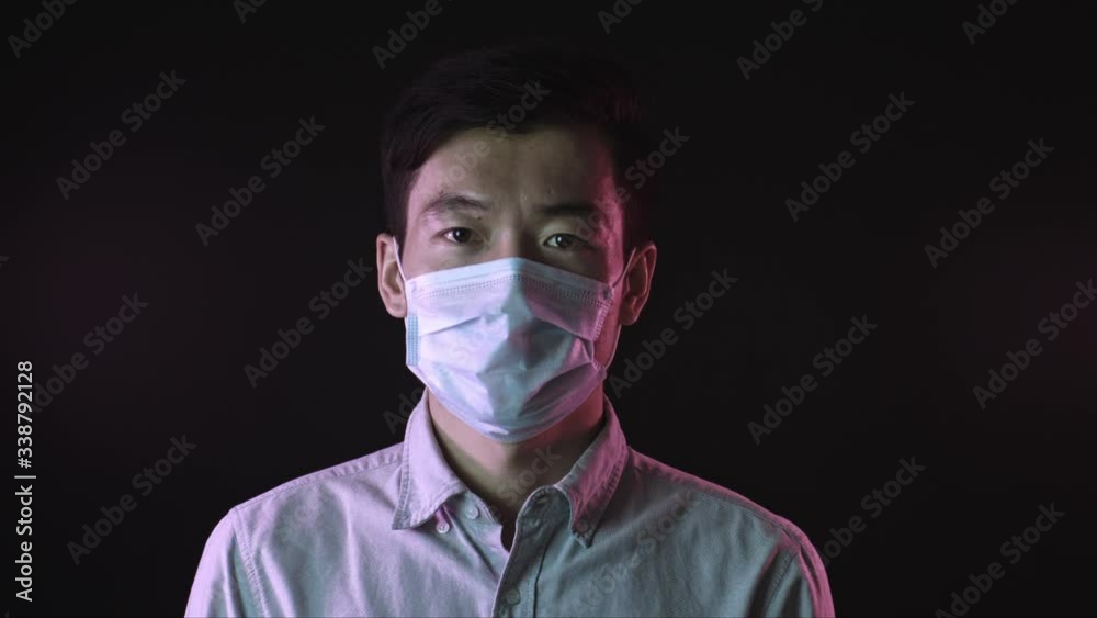 Asian man in protective mask against covid-19 coughing aside. Pandemic disease Asian man in protective mask against covid-19 coughing aside. Pandemic disease