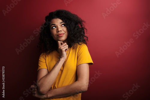 Image of brunette african american woman thinking and touching her chin