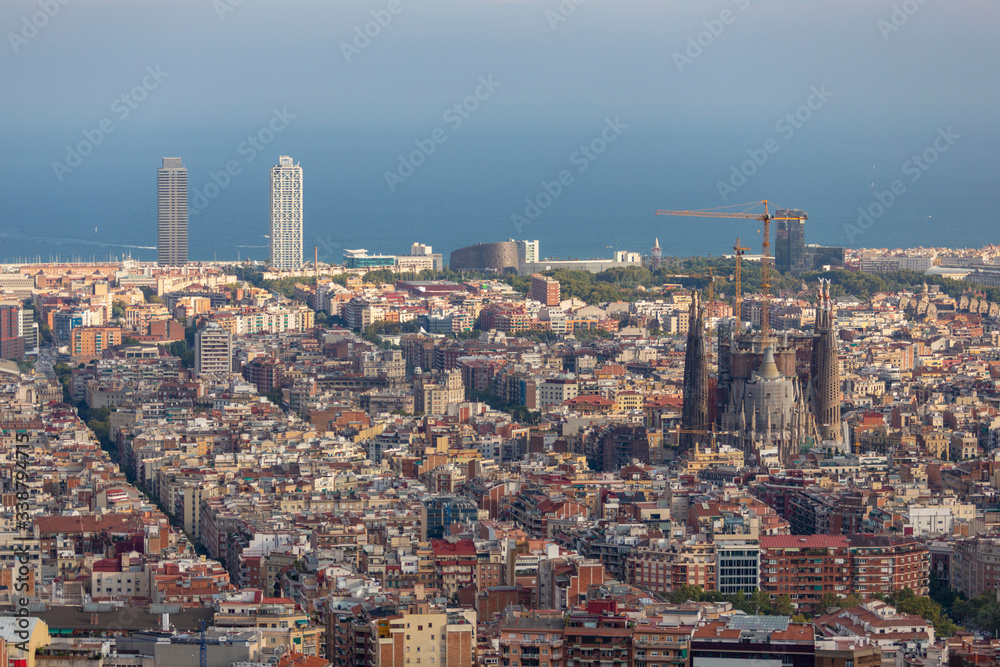 Barcelona city view from a high point with Sagrada Familia Cathedral in the middle and the sea at the background