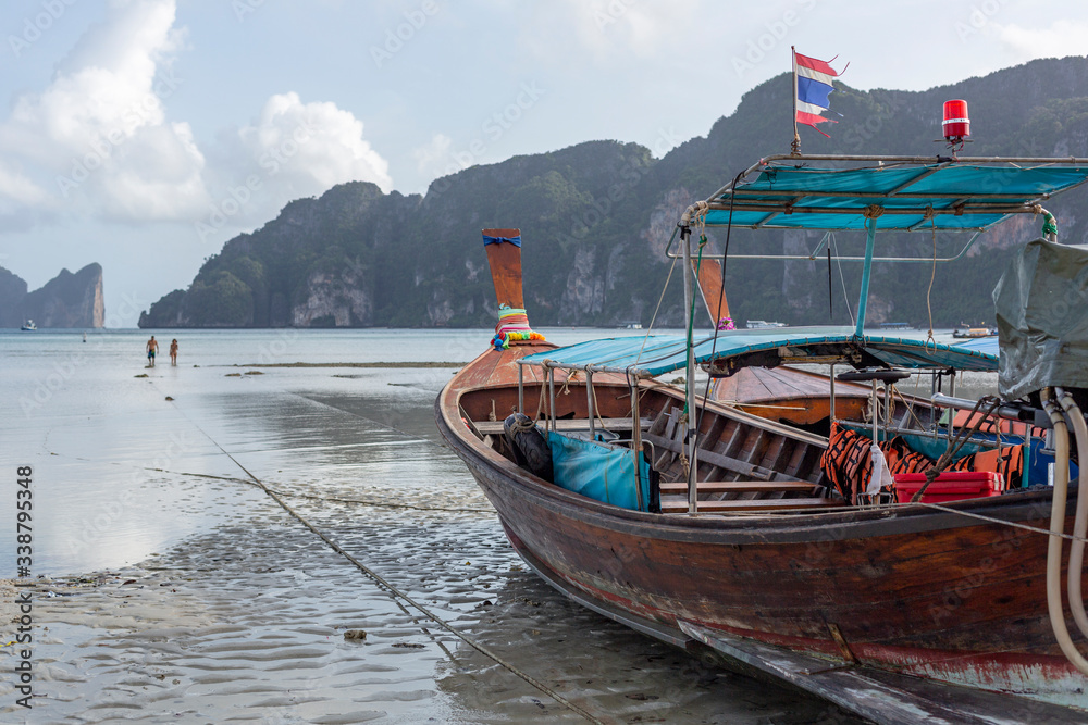 A low tide beach with a boat on the sand in Koh Phi Phi island, Thailand