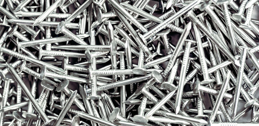 Long banner Construction nails screws. Gray metal background, nickel-plated nails