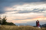 Beautiful wedding couple covered in blanket posing in countryside