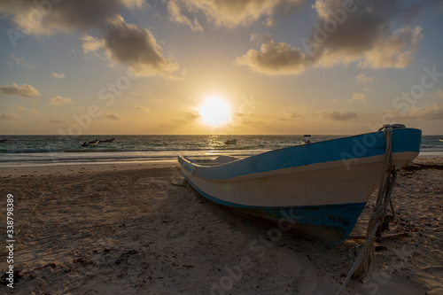 A boat in the sand is waiting for the sunlight in an amazing dawn in Tulum, Quintana Roo, Mexico