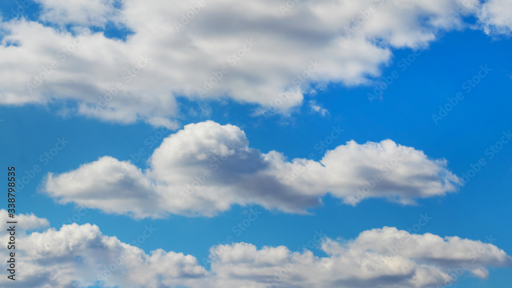 Obraz premium White fluffy clouds in light blue sky