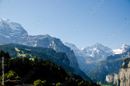 Picturesque Alpine village Wengen  Switzerland. Famous Lauterbrunnen and Staubbach Falls in background. Swiss Alps with snow on top. Switzerland in summer. Alpine landscape