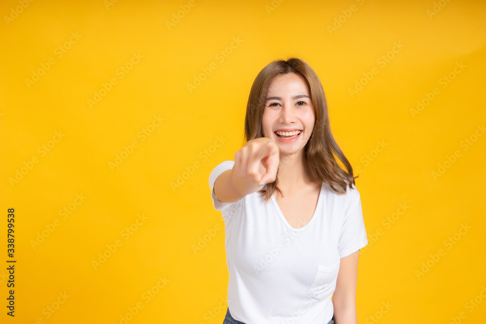 Portrait young happy asian woman smile laughing standing enjoy fun relaxing carefree positive emotion in white t-shirt, Yellow background isolated studio shot and copy space. Portrait young happy asian woman smile laughing standing enjoy fun relaxing carefree positive emotion in white t-shirt, Yellow background isolated studio shot and copy space.