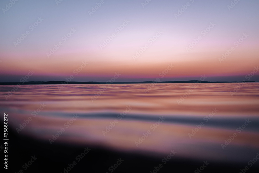 view of the water of the sea at sunset, red scarlet sky with reflections.