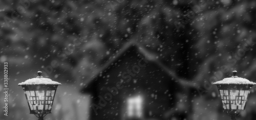 winter with house lanterns in snowfall at moon night. black and white