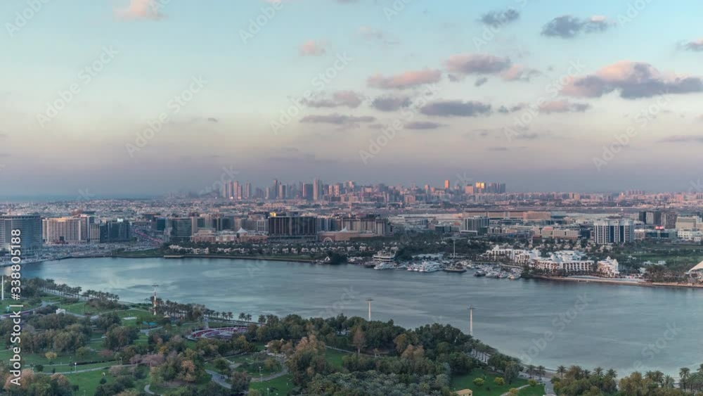 Skyline of new modern city with green trees in park Aerial Timelapse in Dubai Creek, Dubai city, United Arab Emirates at warm evening during sunset Skyline of new modern city with green trees in park Aerial Timelapse in Dubai Creek, Dubai city, United Arab Emirates at warm evening during sunset