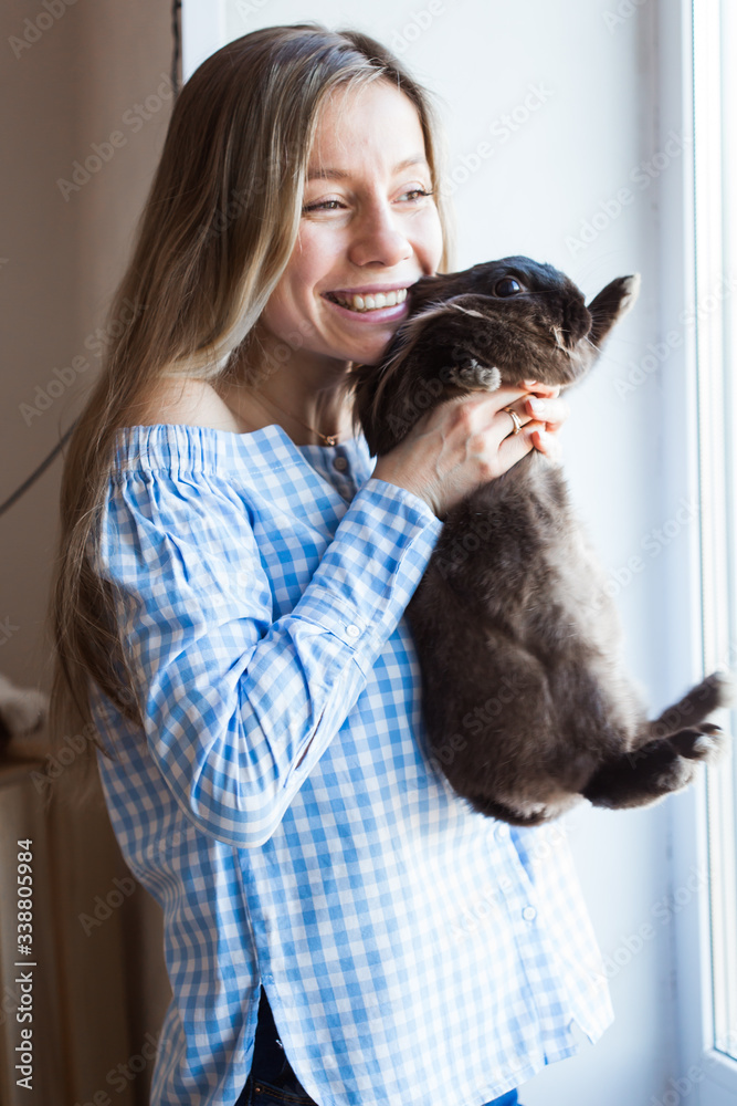 Pet and Easter concept - Happy girl hugging brown rabbit at home. Pet and Easter concept - Happy girl hugging brown rabbit at home.