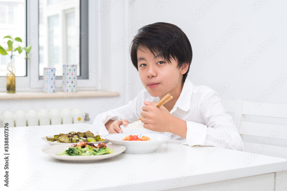 Handsome Asian boy eating with chopsticks Handsome Asian boy eating with chopsticks