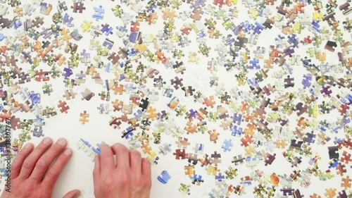 Top view of a man doing a jigsaw puzzle
