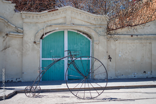 White stone walls on the old pedestrian street of Kazan. Old buildings and modern art-a figure of an old Bicycle made of metal