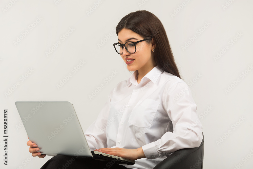 beautiful young woman in glasses on a white background with a laptop beautiful young woman in glasses on a white background with a laptop