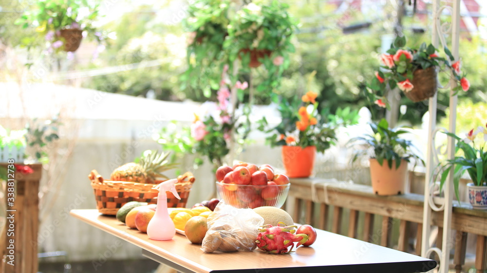 Prepared various fruits during home self-isolation. Vitamins boost immunity. Apples, pitaya, kiwi, cantaloupe, and mango on the table. Home balcony planting background.