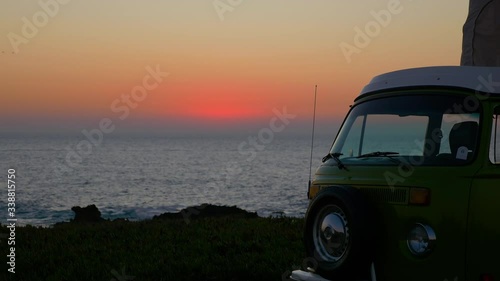 Spectacular sunset over the Atlantic Ocean with a retro camper van in Cabo de Roca. Green combi T1 Westfalia .