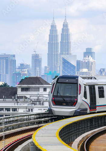 Malaysia Mass Rapid Transit (MRT) train with a background of Kuala Lumpur cityscape. People commute with MRT as transportation to work, school, travel, and shopping.