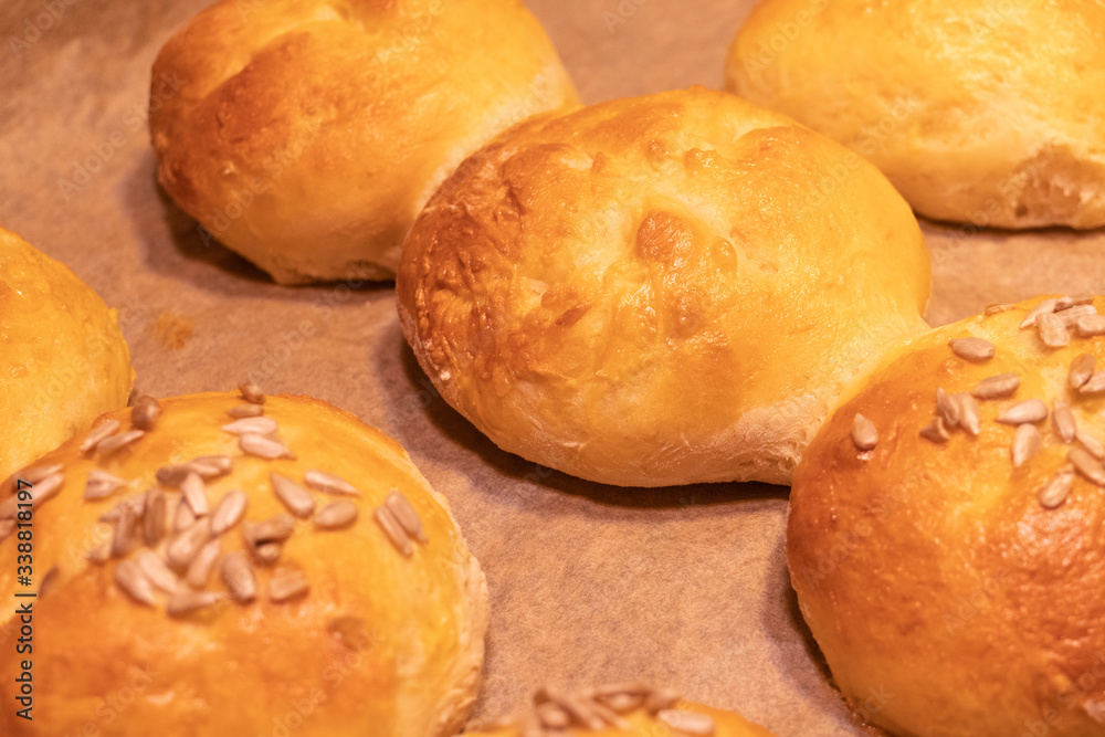 Home made bread rolls or buns for breakfast fresh on a paper on a table, selected focus, narrow depth of field