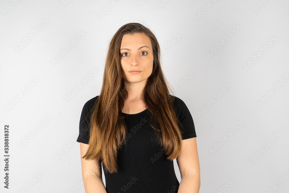 Young woman make serious face in black shirt with long hair Young woman make serious face in black shirt with long hair