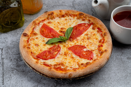 Classic mini-pizza margherita with tomatoes and melted cheese, a psrt of kids menu in a cafe