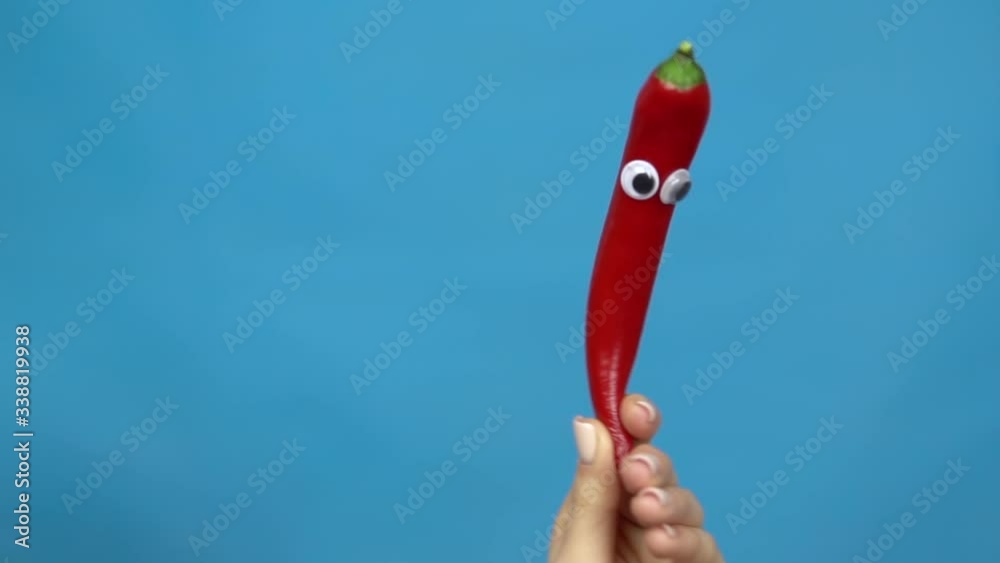 Chilli pepper eyes in a woman hand closeup. Chilli pepper shakes and