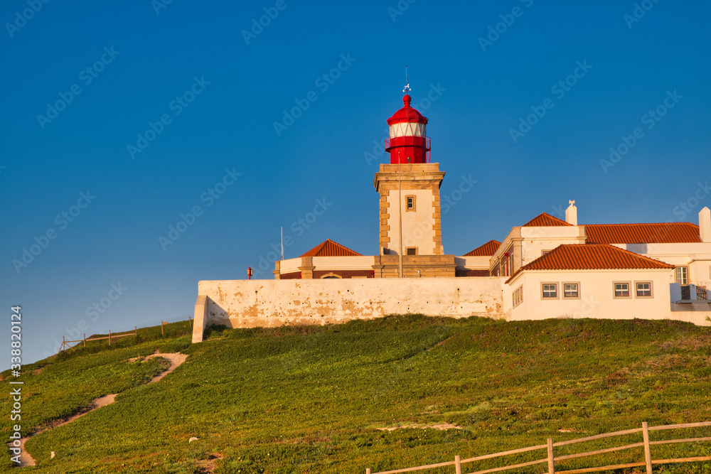 Cabo da Roca, Portugal - white lighthouse on cliffs at evening time.