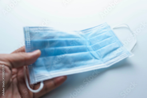blurry hand holding face mask  isolated white