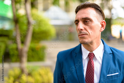 Wallpaper Mural Mature handsome Italian businessman relaxing outside of the building Torontodigital.ca