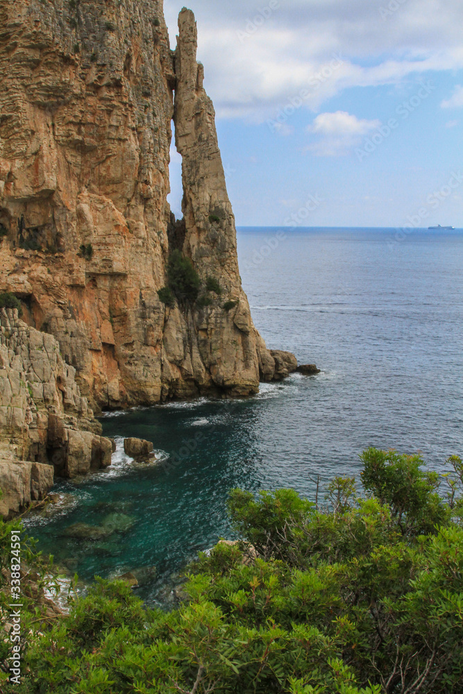 Seascape of the mediterranean sea at the italian island of Sardinia with steam cliffs at the eastern coast (vertical)