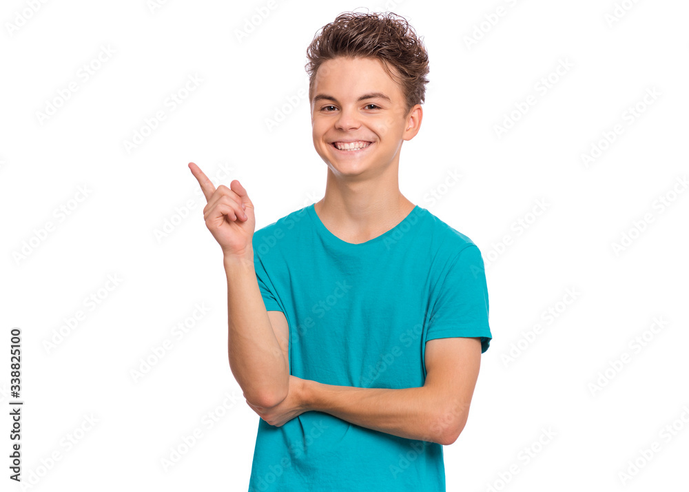 Portrait of teen boy pointing fingers away at copyspace, isolated on white background. Cute caucasian young teenager smiling and attracted by attention pointing fingers at something. Happy child. Portrait of teen boy pointing fingers away at copyspace, isolated on white background. Cute caucasian young teenager smiling and attracted by attention pointing fingers at something. Happy child.